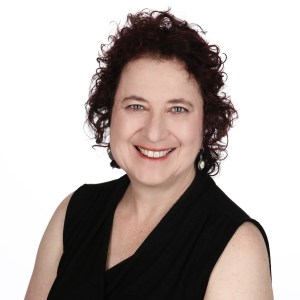 Headshot of Elana Varon, who is smiling and wearing a black sleeveless top.